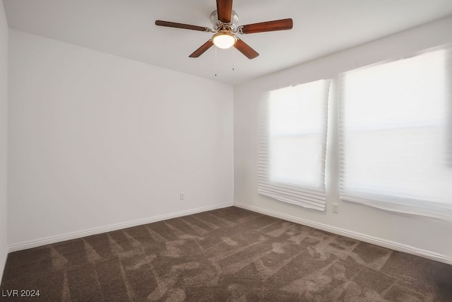 empty room featuring dark carpet and ceiling fan