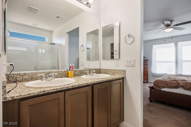 bathroom with vanity, a shower with shower door, and ceiling fan