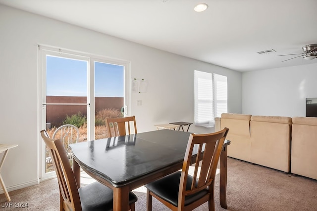 carpeted dining space with ceiling fan