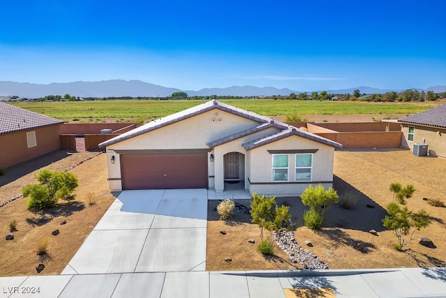 view of front of property with a mountain view, a rural view, and a garage