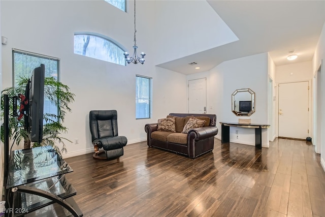 living room with hardwood / wood-style floors, a high ceiling, and a notable chandelier