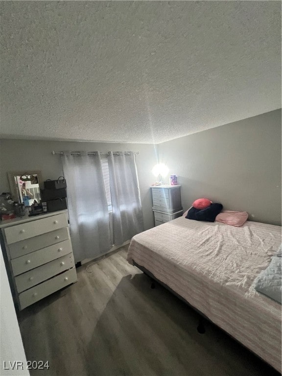 bedroom with a textured ceiling and hardwood / wood-style floors