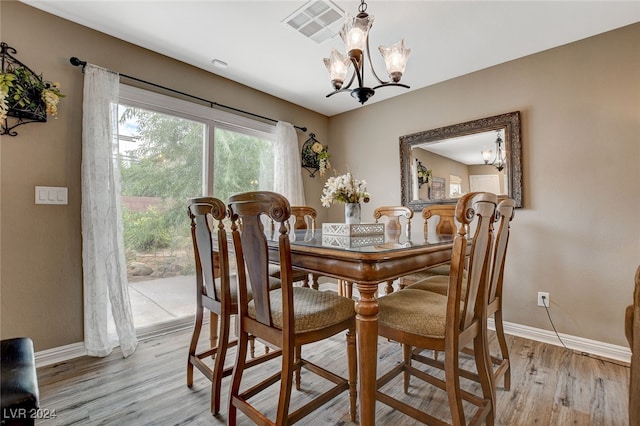 dining area with a chandelier and light hardwood / wood-style floors