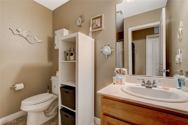 bathroom with vanity, toilet, and tile patterned flooring