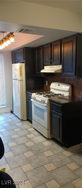 kitchen with white appliances, dark brown cabinets, and tasteful backsplash