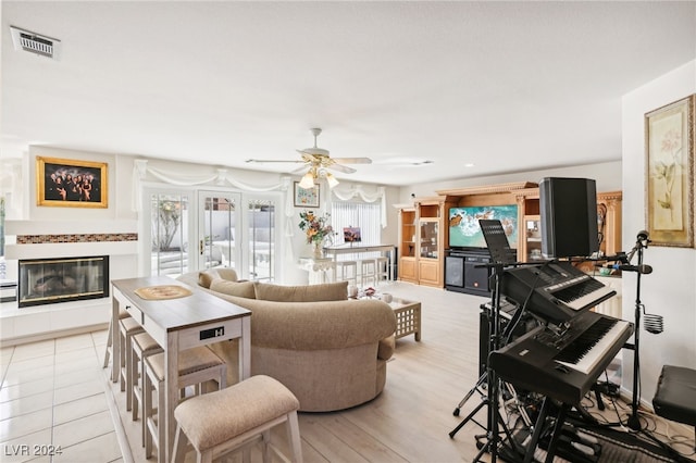 tiled living room with ceiling fan and french doors