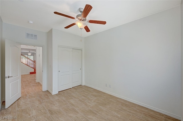 unfurnished bedroom featuring ceiling fan and a closet