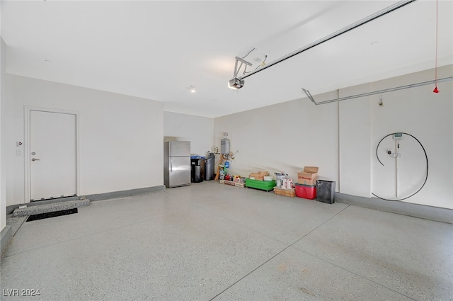 garage featuring stainless steel refrigerator, a garage door opener, and water heater