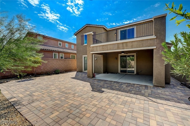 rear view of house with a patio and a balcony