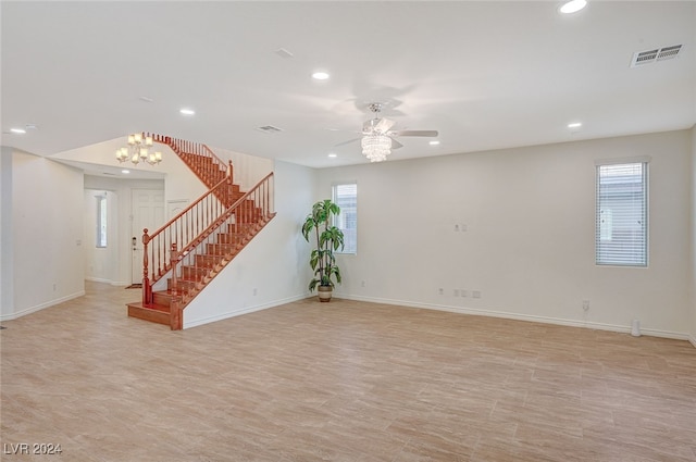 unfurnished room featuring ceiling fan with notable chandelier