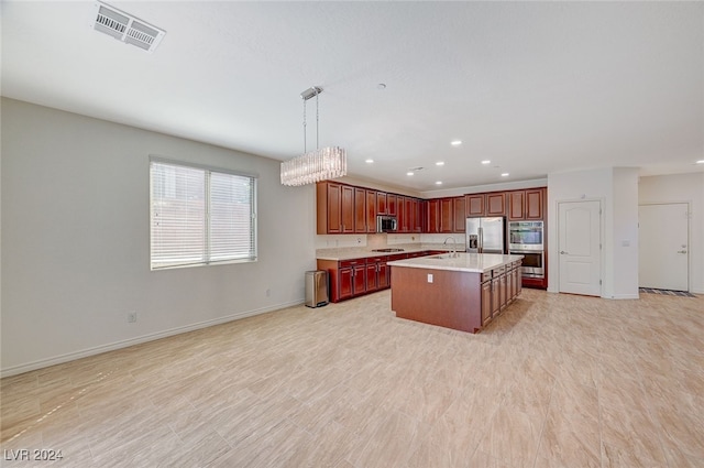 kitchen featuring pendant lighting, an island with sink, a chandelier, appliances with stainless steel finishes, and light hardwood / wood-style floors