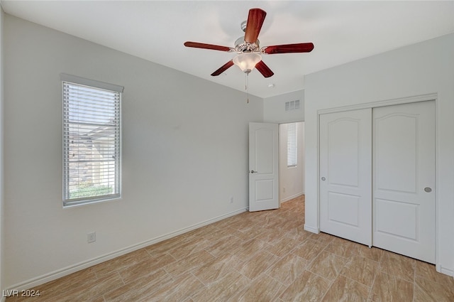 unfurnished bedroom with ceiling fan and a closet