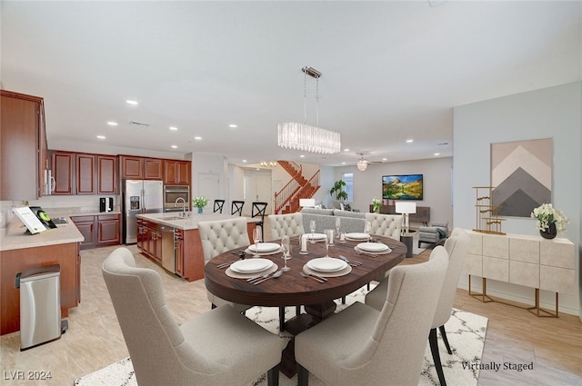 dining room featuring light wood-type flooring, sink, and a chandelier