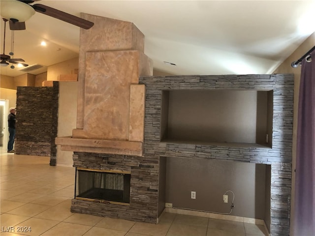 unfurnished living room with a fireplace, light tile patterned flooring, ceiling fan, and vaulted ceiling