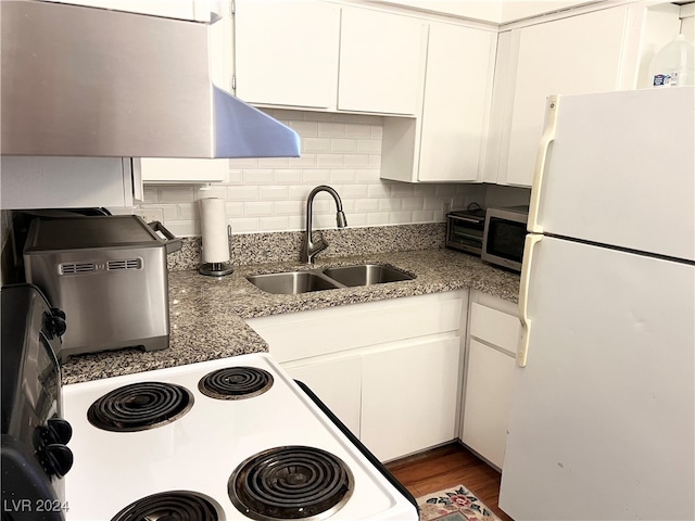 kitchen featuring light stone counters, white refrigerator, dark wood-type flooring, sink, and white cabinets