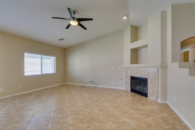 unfurnished living room featuring a high ceiling, ceiling fan, light tile patterned flooring, and a fireplace