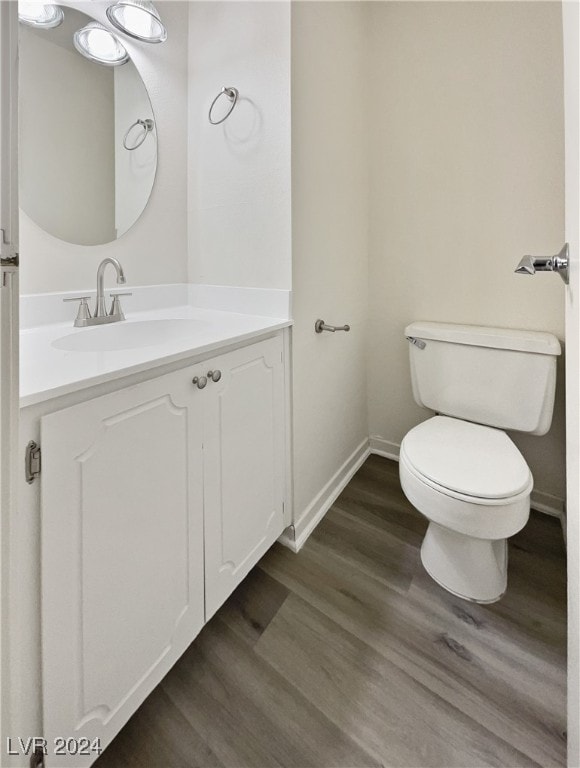 bathroom with vanity, toilet, and wood-type flooring