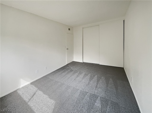 unfurnished bedroom featuring carpet and a closet