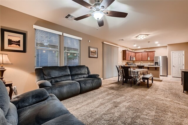 carpeted living room with ceiling fan