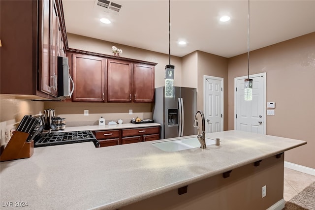 kitchen with hanging light fixtures, stainless steel appliances, sink, and kitchen peninsula