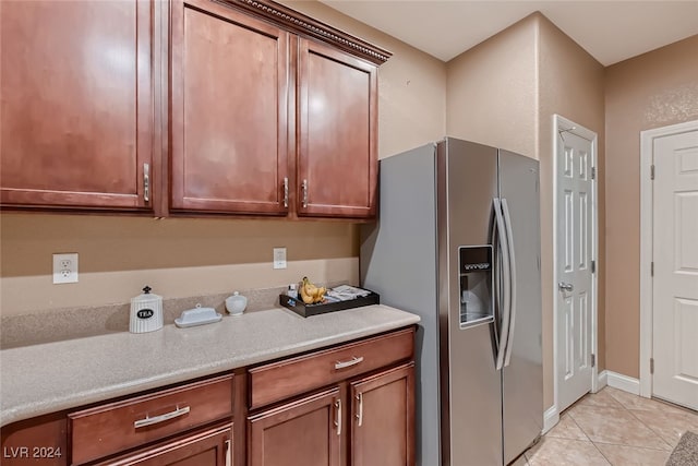 kitchen with stainless steel fridge with ice dispenser and light tile patterned flooring