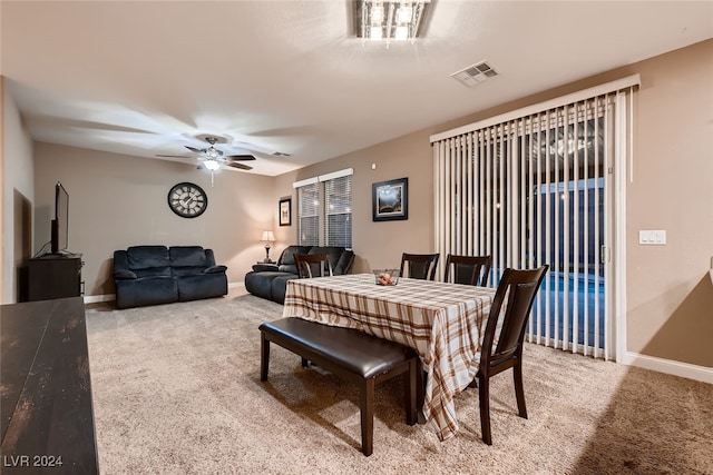 carpeted dining area with ceiling fan