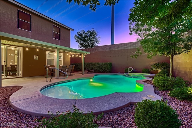 pool at dusk with a patio area