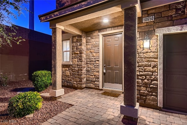 exterior entry at twilight featuring a garage