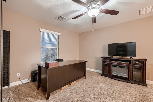 office space featuring ceiling fan, light colored carpet, and a textured ceiling