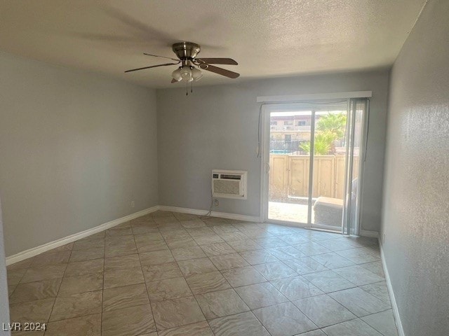 unfurnished room with a textured ceiling, ceiling fan, and an AC wall unit