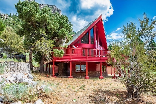 back of house with a wooden deck and faux log siding