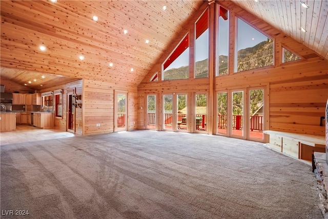 unfurnished living room featuring wooden walls, wood ceiling, high vaulted ceiling, and light carpet