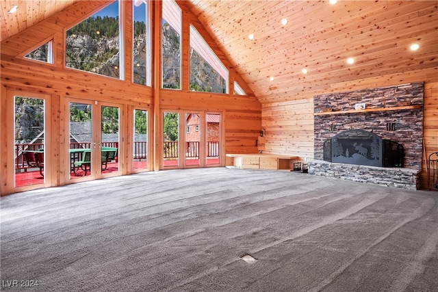 unfurnished living room with high vaulted ceiling, wooden walls, carpet flooring, wood ceiling, and a stone fireplace