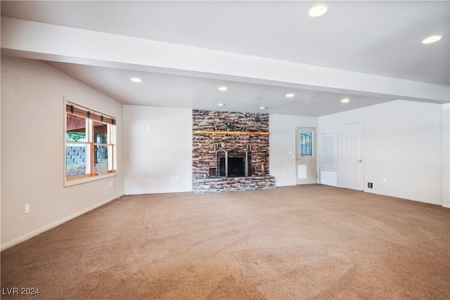 unfurnished living room featuring carpet flooring and a stone fireplace