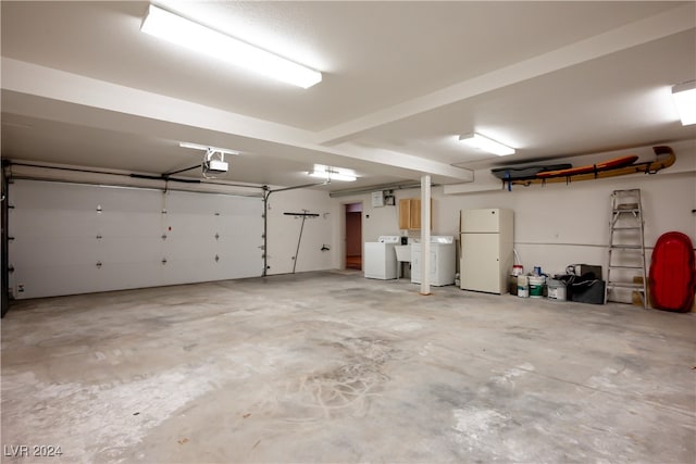 garage featuring washer / dryer, a garage door opener, and white fridge