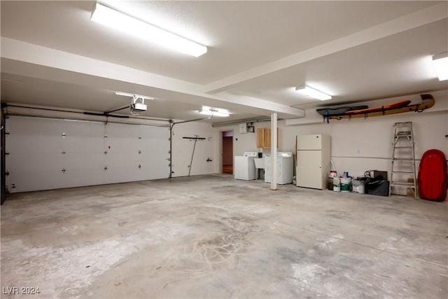garage with freestanding refrigerator, a garage door opener, and washer / clothes dryer