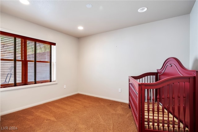 bedroom with light carpet and a crib