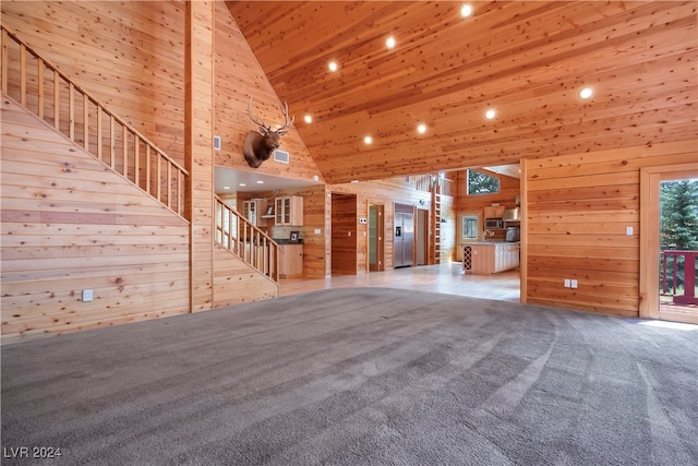 unfurnished living room with wood walls, light carpet, and high vaulted ceiling