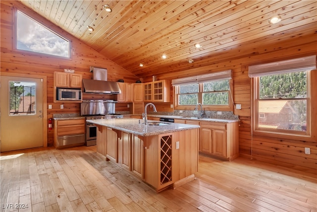 kitchen featuring a center island with sink, wood ceiling, a breakfast bar, stainless steel appliances, and sink