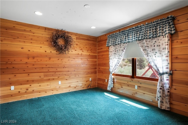 carpeted empty room featuring wood walls