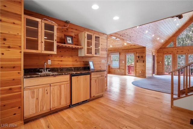 kitchen with light brown cabinetry, wooden walls, and light hardwood / wood-style floors