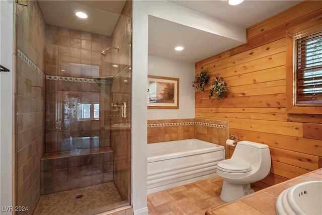 bathroom with toilet, a wealth of natural light, separate shower and tub, and wooden walls