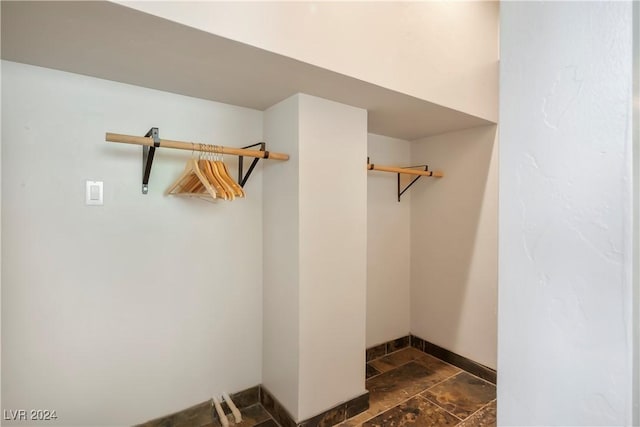 spacious closet featuring stone tile flooring