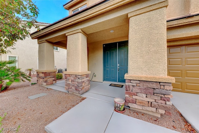 doorway to property with covered porch and a garage