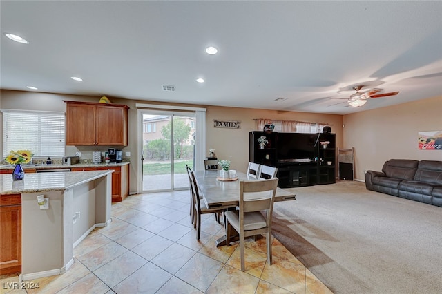 dining area featuring light carpet and ceiling fan