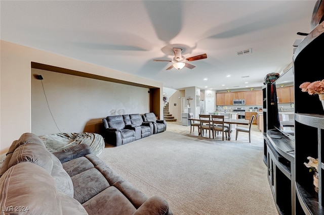 carpeted living room featuring ceiling fan