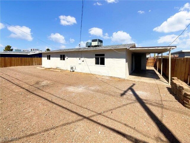 back of house featuring a carport