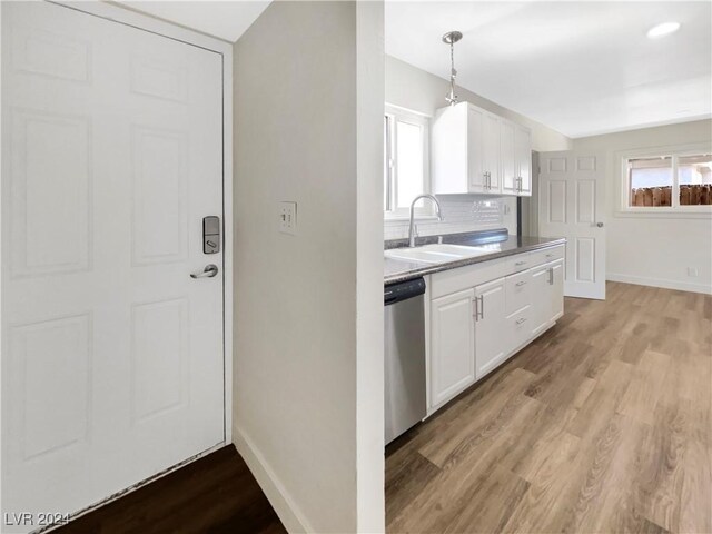 kitchen with dishwasher, light hardwood / wood-style floors, hanging light fixtures, sink, and white cabinetry