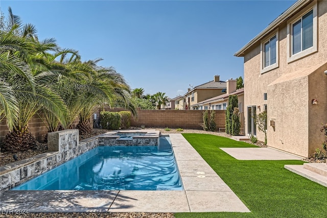 view of swimming pool featuring a lawn and an in ground hot tub