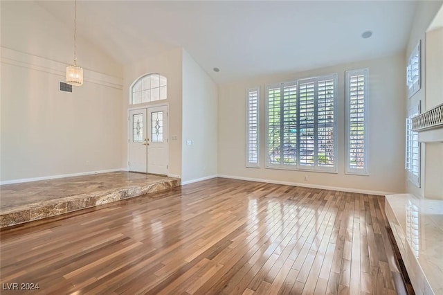 unfurnished living room featuring hardwood / wood-style flooring and vaulted ceiling